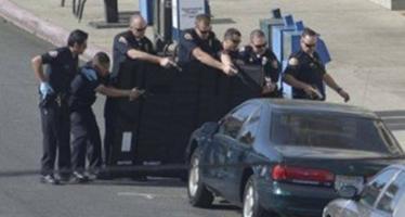 Long Beach police have dished out millions in settlements because of multiple incidents where they shot people dead. Here they approach a woman in a car after shooting her in 2013. Photo via Orange County Register.